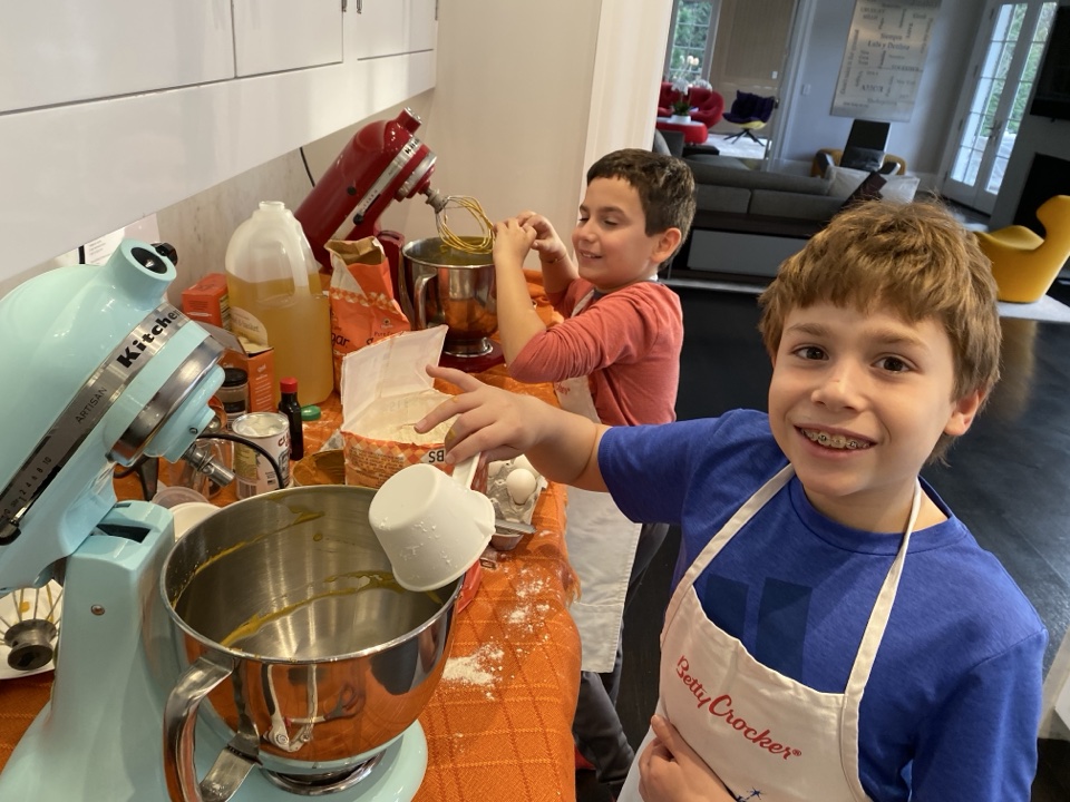 Two young PeaceofCakes bakers working with a mixer and flour